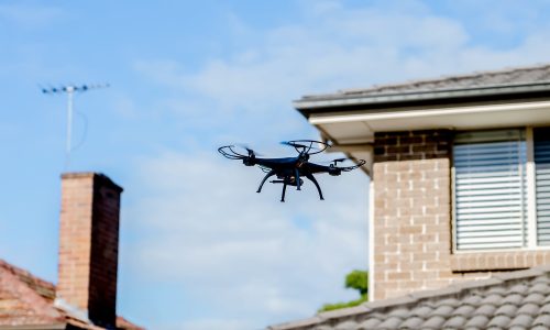 Drone camera quad copter flying over the roofs. Drone photography and videography. Drone flight in the sky